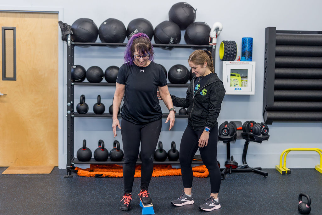 Runner working with a physical therapist on strength and performance training at a sports performance clinic in Lunenburg, MA